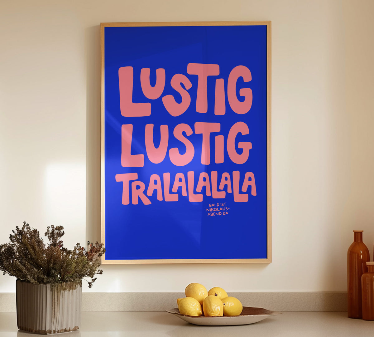 Gerahmtes Weihnachts-Poster „Lustig Lustig Tralalalala“ in der Farbe Marine Blau/Pink über einem dekorierten Sideboard.