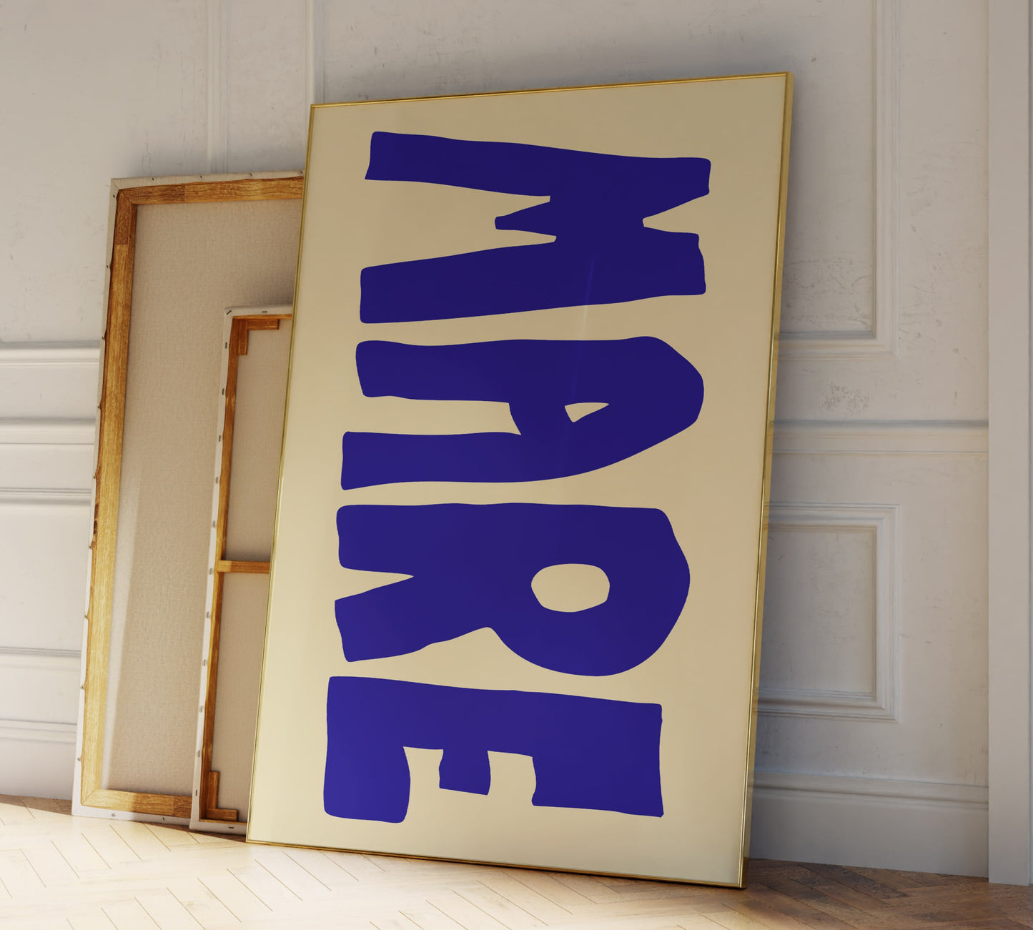 Two frames leaning against a modern living room wall, in big blue letters the Italian word "MARE" for ocean is printed on it.