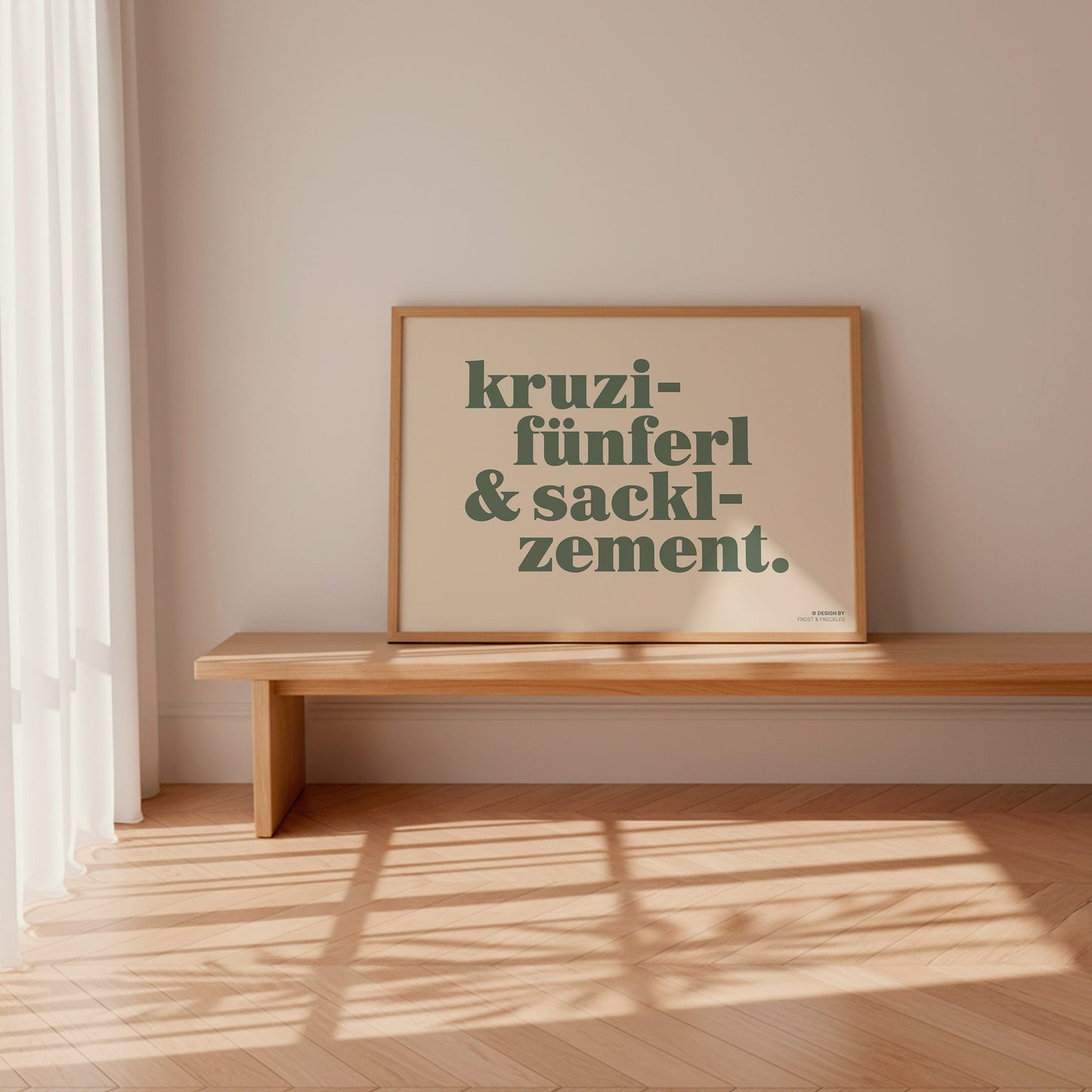 Ein gerahmtes Dialekt-Wandbild in einem hellen Eichenholzrahmen, der an einer cleanen, minimalistischen Altbauwand lehnt.