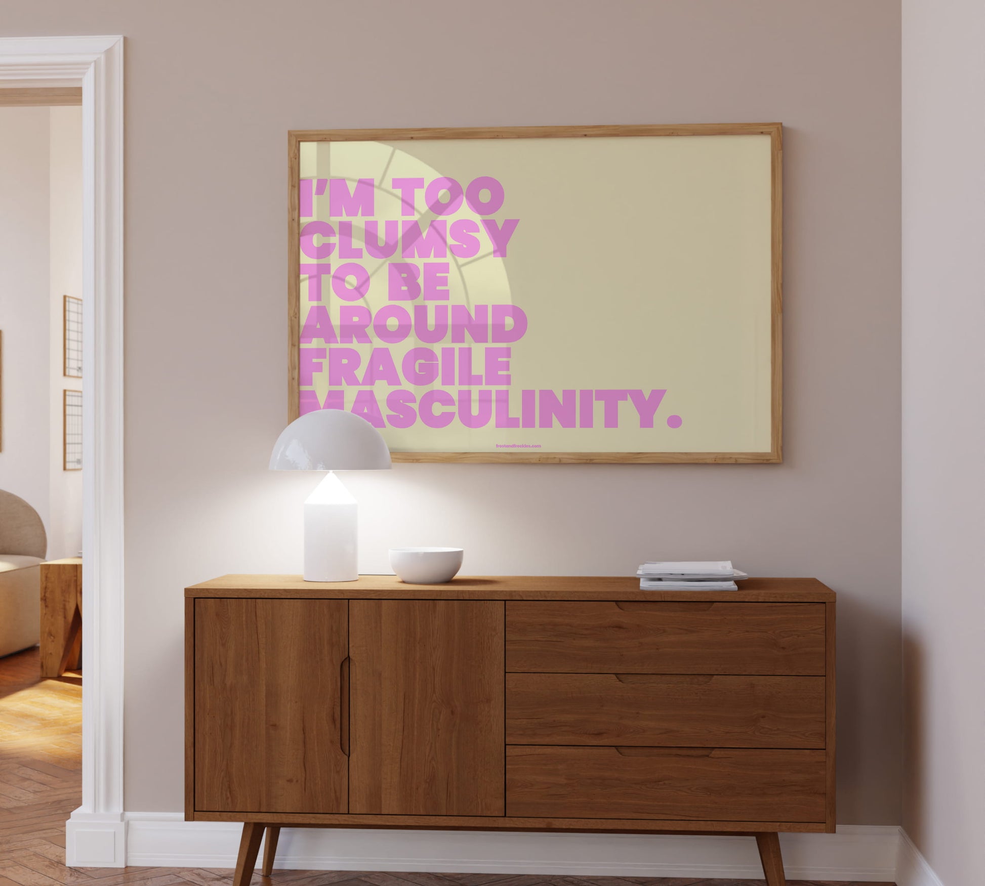 Lifestyle-Foto: Das farbintensive „fragile masculinity“ Spruch-Poster kombiniert mit minimalistischen Deko-Objekten über eine Kommode hängend.