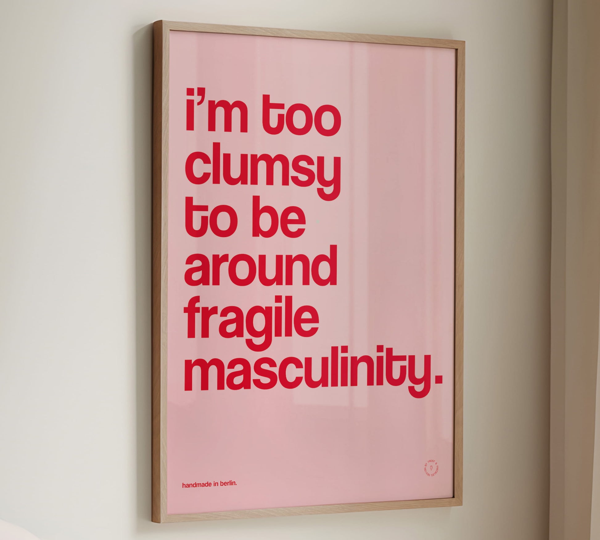 Ein gerahmtes Statement-Poster in Pink und Rot mit dem Feminismus Spruch "I'm Too Clumsy To Be Around Fragile Masculinity"
