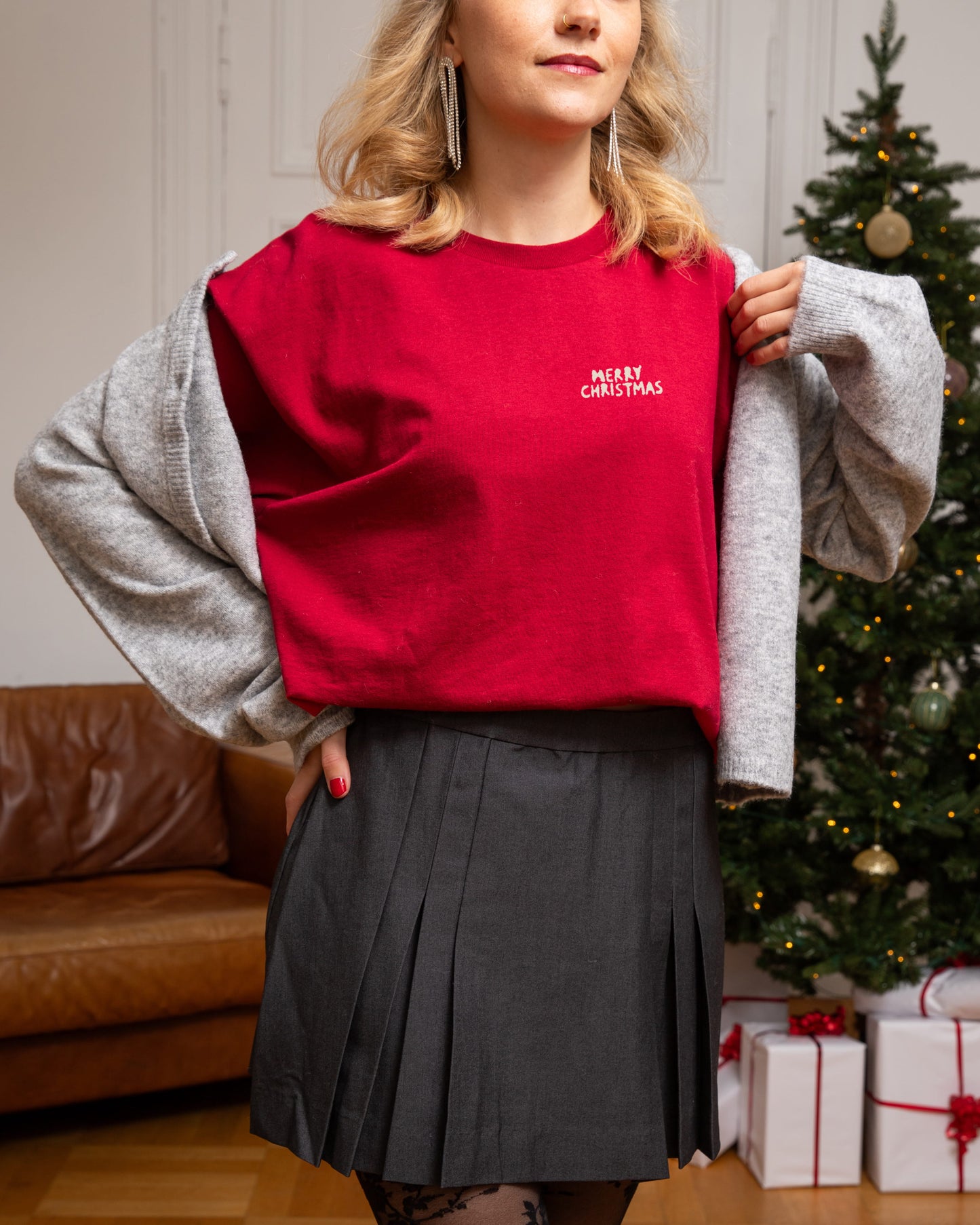 Gemütliches Holiday-Outfit: Das Weihnachts-T-Shirt in der Farbe Cardinal Red (Rot) kombiniert mit einer hellen Hose.