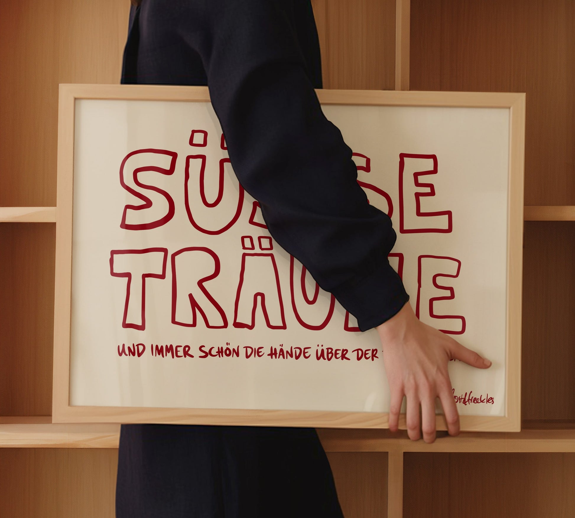 Ein gerahmtes "Gute Nacht" Poster mit roter Schrift, das eine Frau unter dem Arm hält.