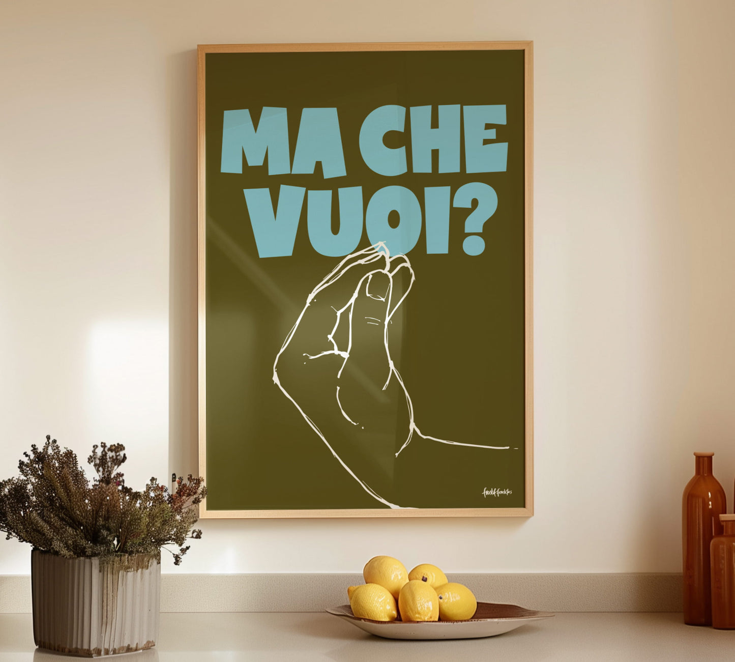 Gerahmtes Ma Che Vuoi Italien-Poster mit Finger Purse Geste in Pastellfarben an einer hellen Wand über einer Küchenzeile.