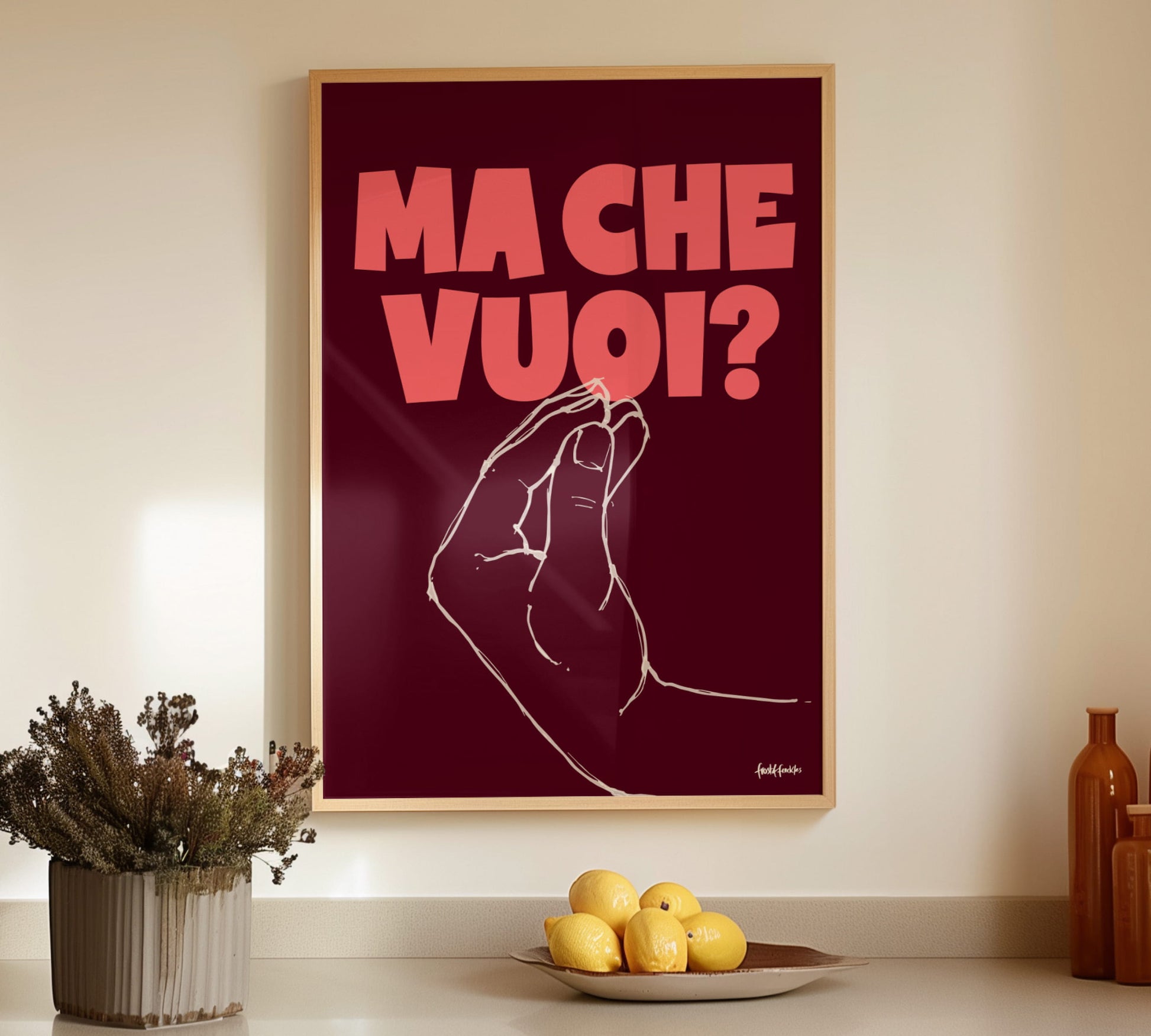 Gerahmtes Italien-Poster mit Pinched-Fingers-Geste an einer hellen Wand über einem Esstisch mit mediterraner Dekoration.