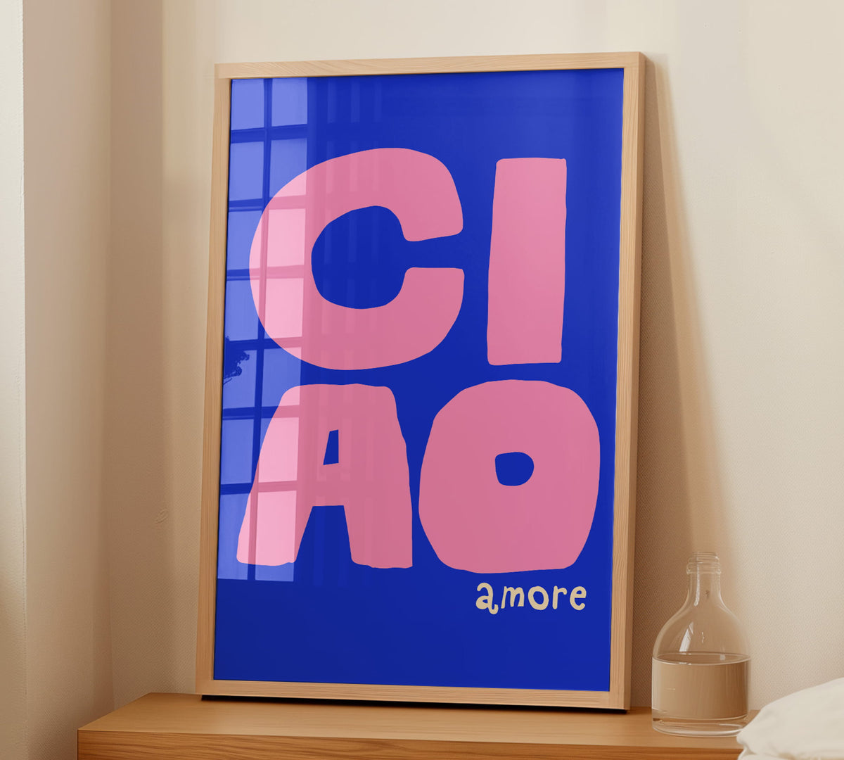 Gerahmtes Italien-Poster Ciao Amore in einem hellen Holzrahmen an einer weißen Wand im Schlafzimmer.