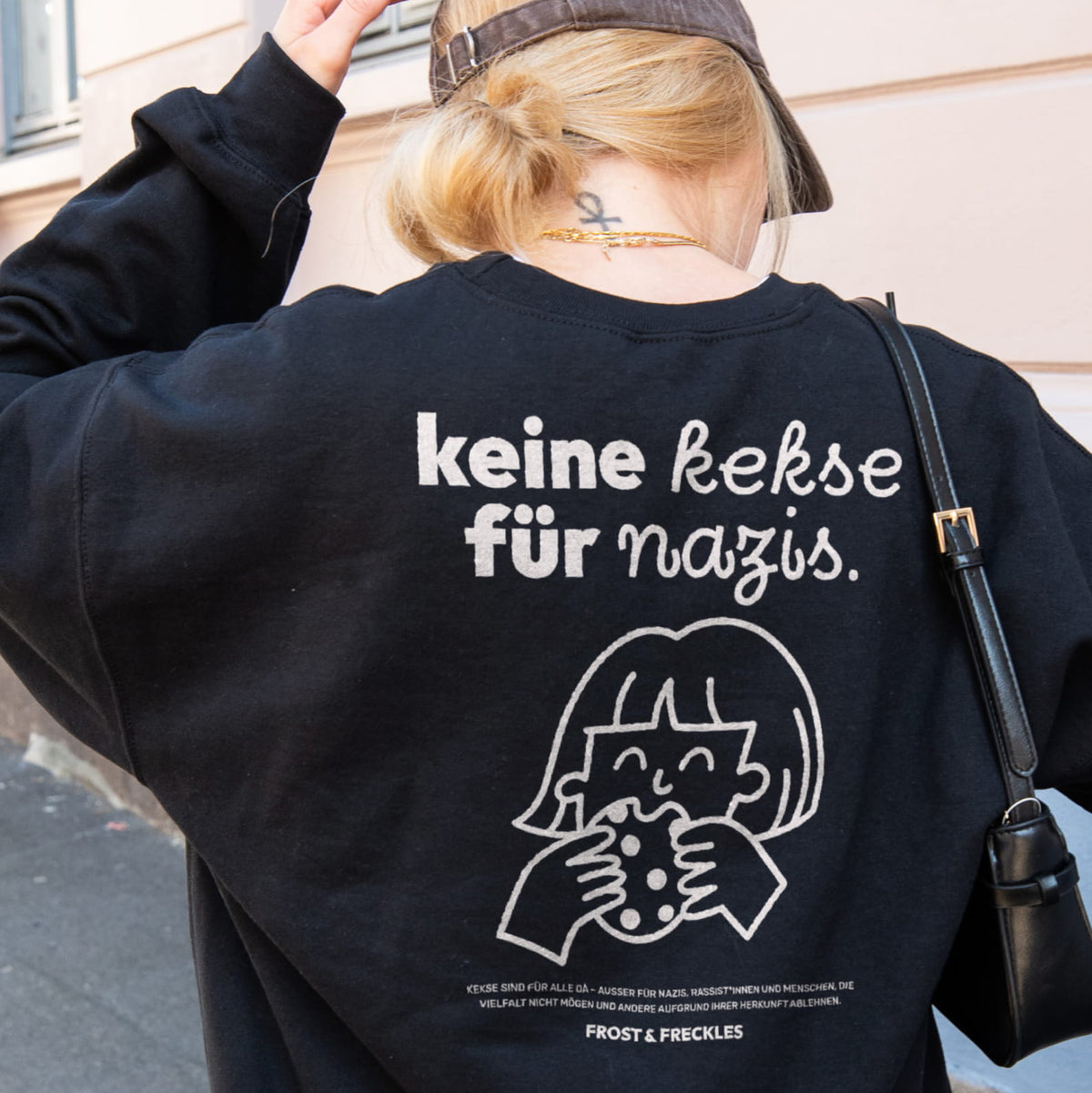 Girl trägt den gemütlichen „Keine Kekse für Nazis“ Oversized Sweater im urbanen Streetwear-Style als Zeichen gegen Rechts, Nazis, Afd und Merz.
