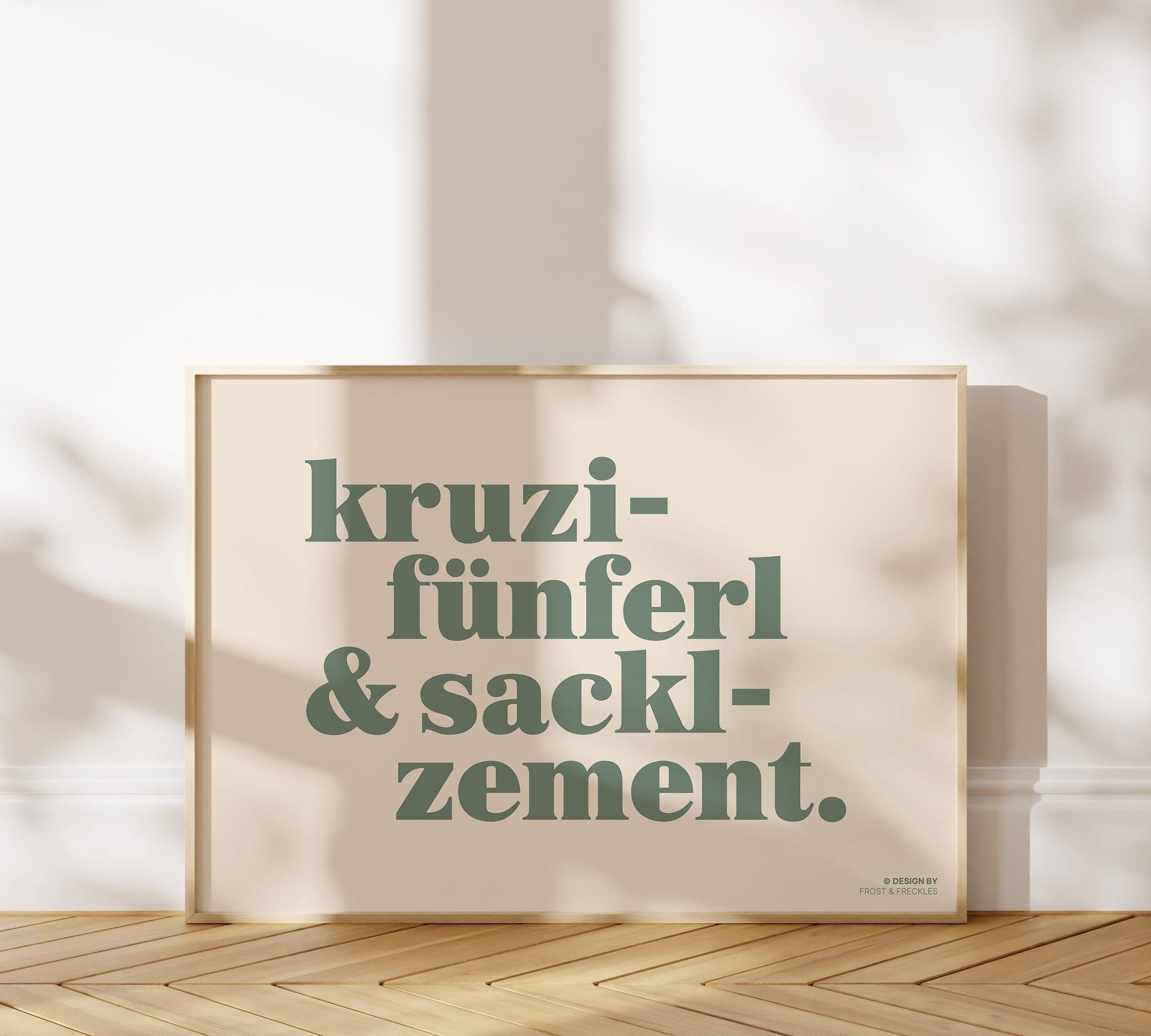 Minimalistisches Typografie-Poster im Querformat mit dem bayerischen Spruch "Kruzifünferl & Sacklzement" in salbeigrüner Serifenschrift auf warmem, beigem Hintergrund.