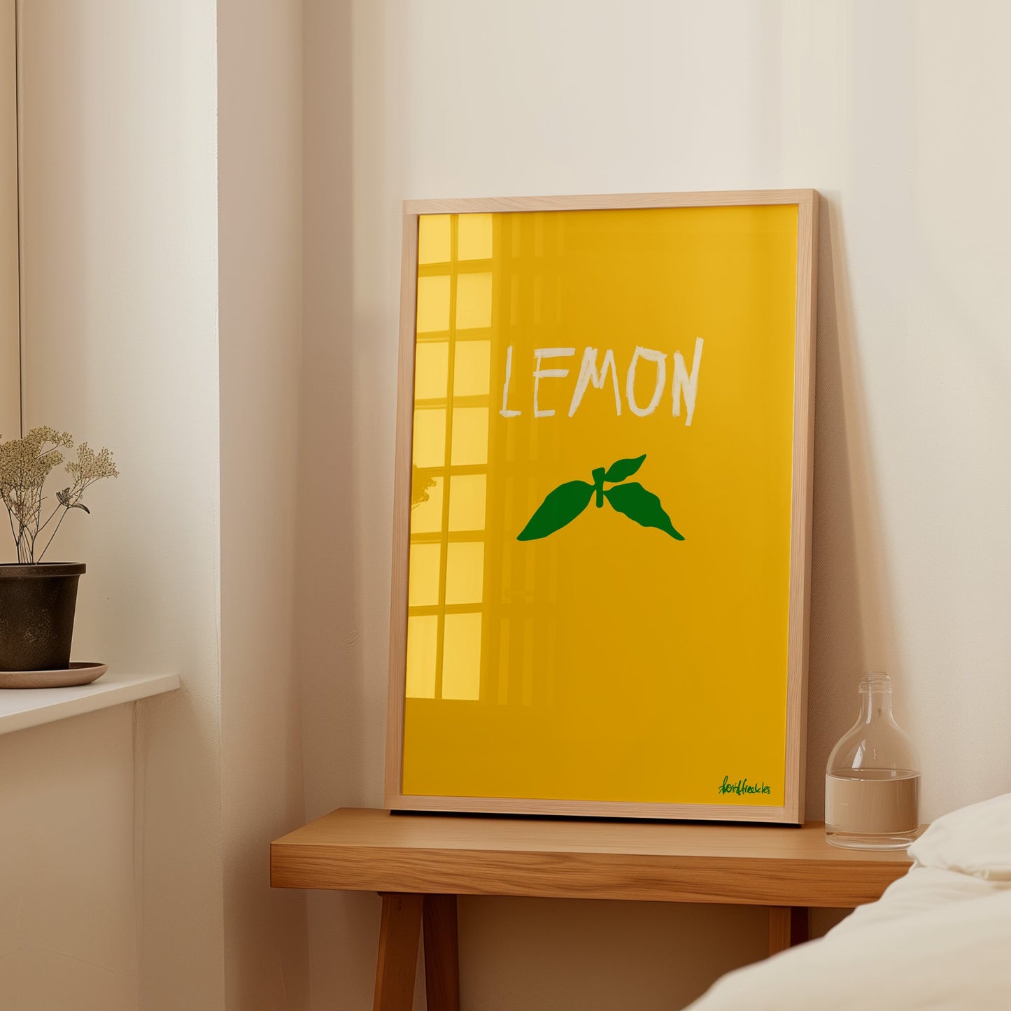 Simple contemporary kitchen poster with a lemon illustration, framed print standing on bedside table