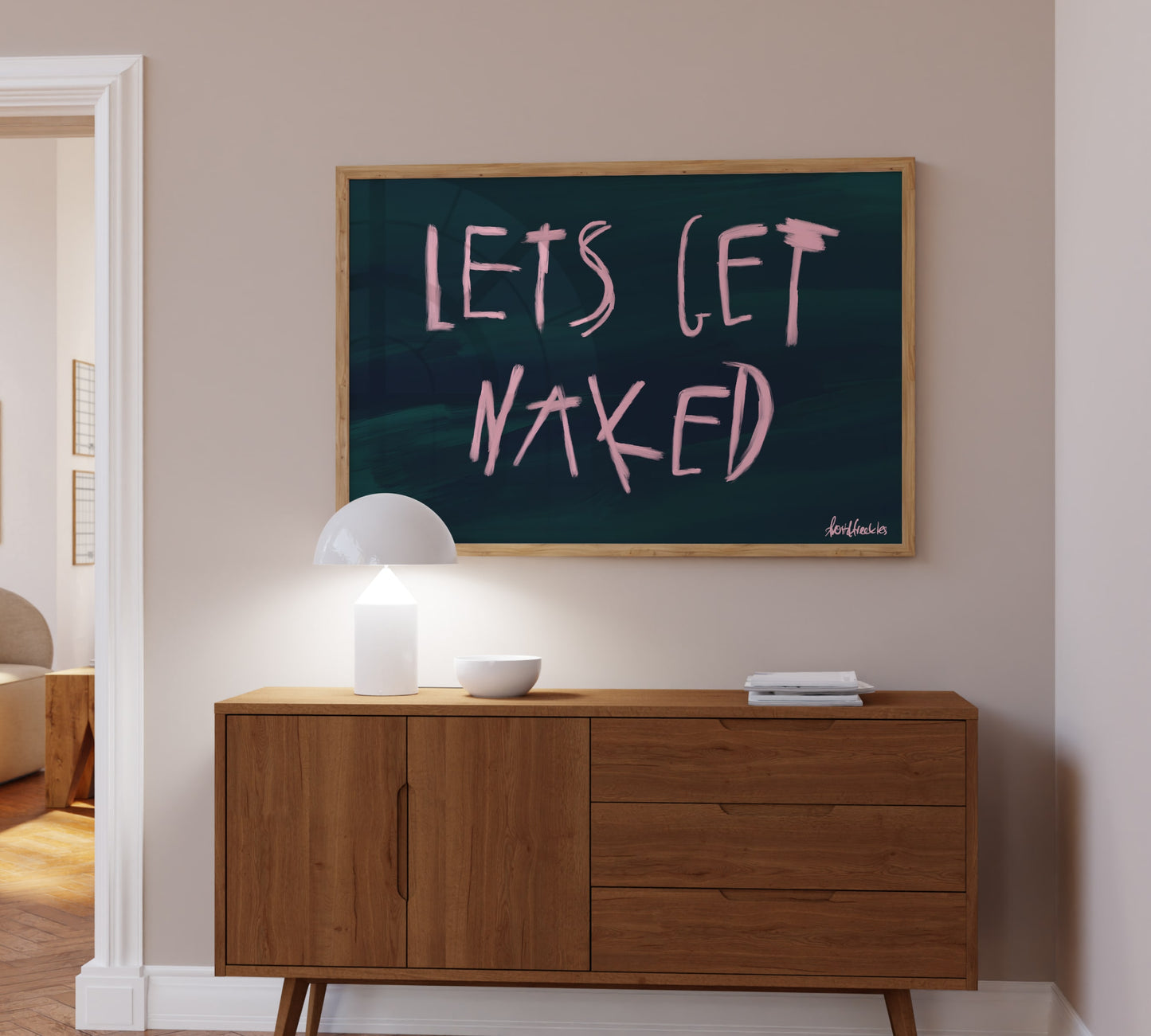 Minimalist nude-themed poster reading "Let's Get Naked" displayed in a boho bedroom, hangin above boho sideboard 
