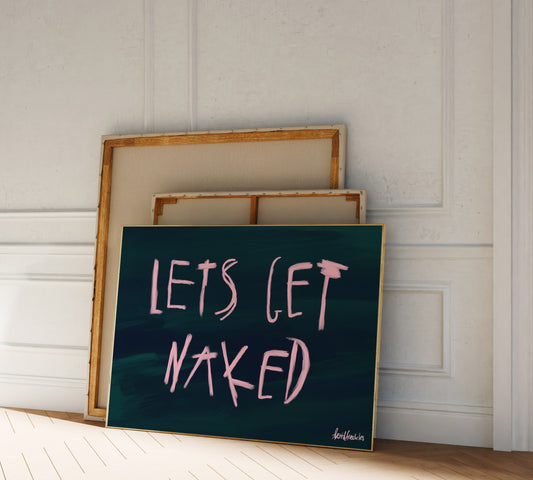 Modern framed quote print "Let's Get Naked" with oil brush lettering in a neutral-toned bedroom with natural light