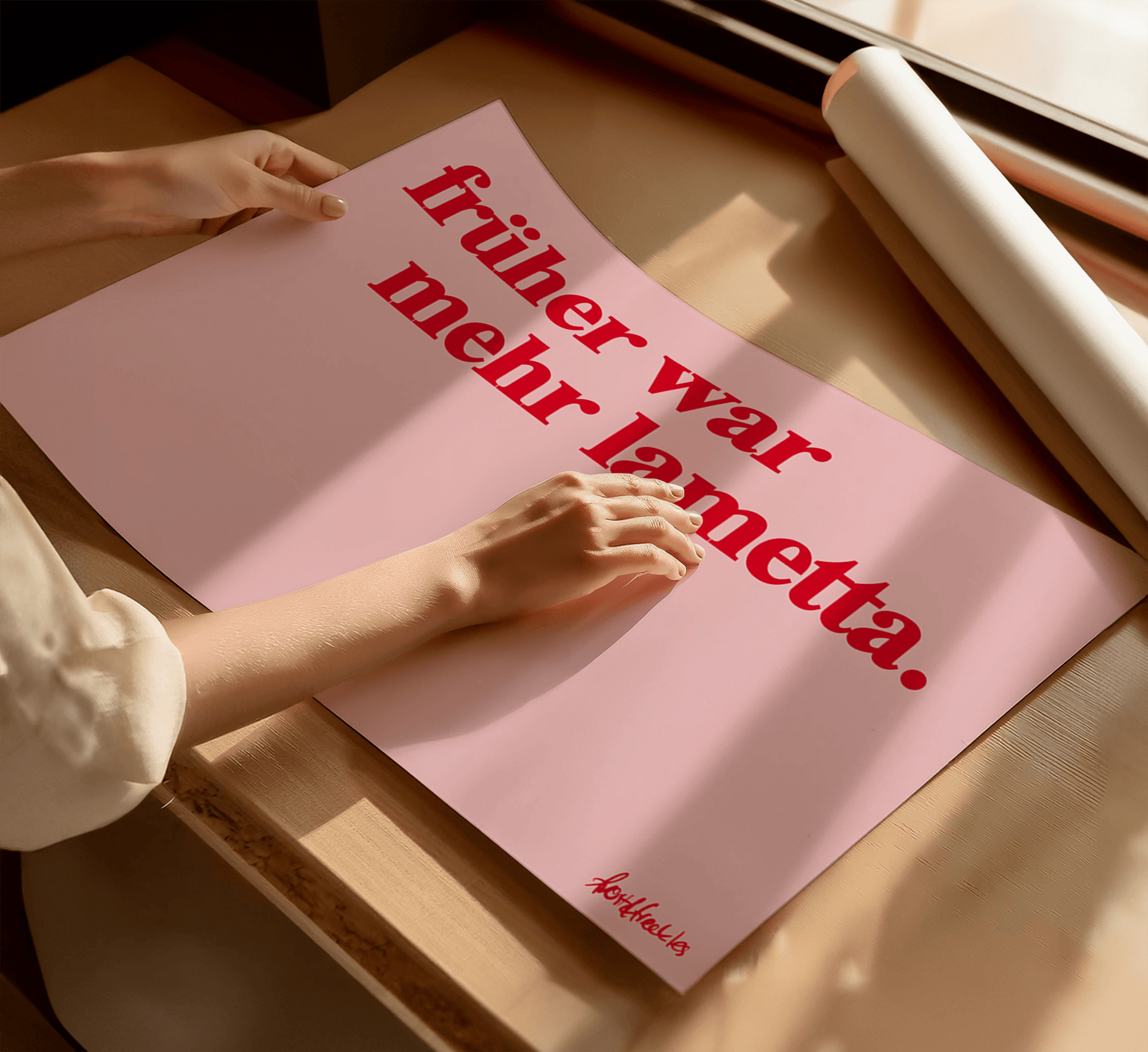 A woman holding a pink poster with the German phrase “Früher war mehr Lametta", a quote by Loriot, in bold red text, on a wooden table near a window with sunlight.