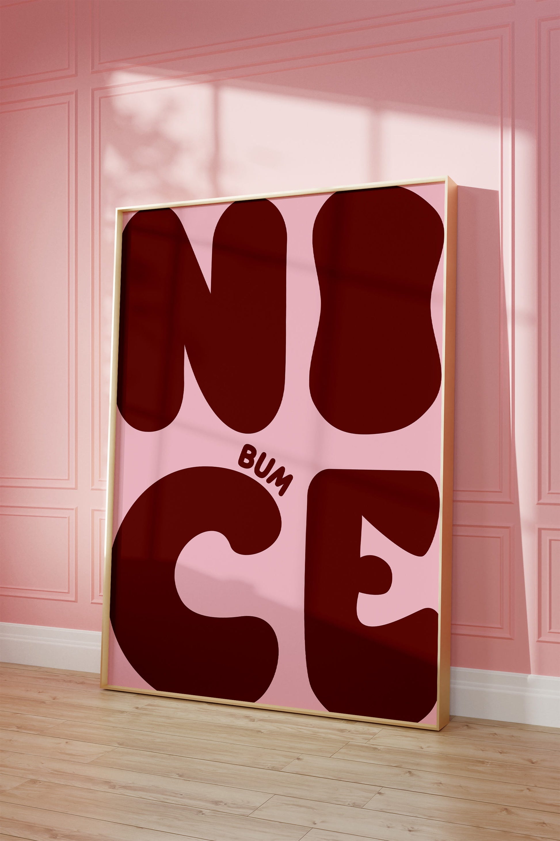 Gerahmtes "Nice Bum" Poster in Eichenholzrahmen, aufgestellt an einer pinken Wand neben der Toilette im Gäste-WC.