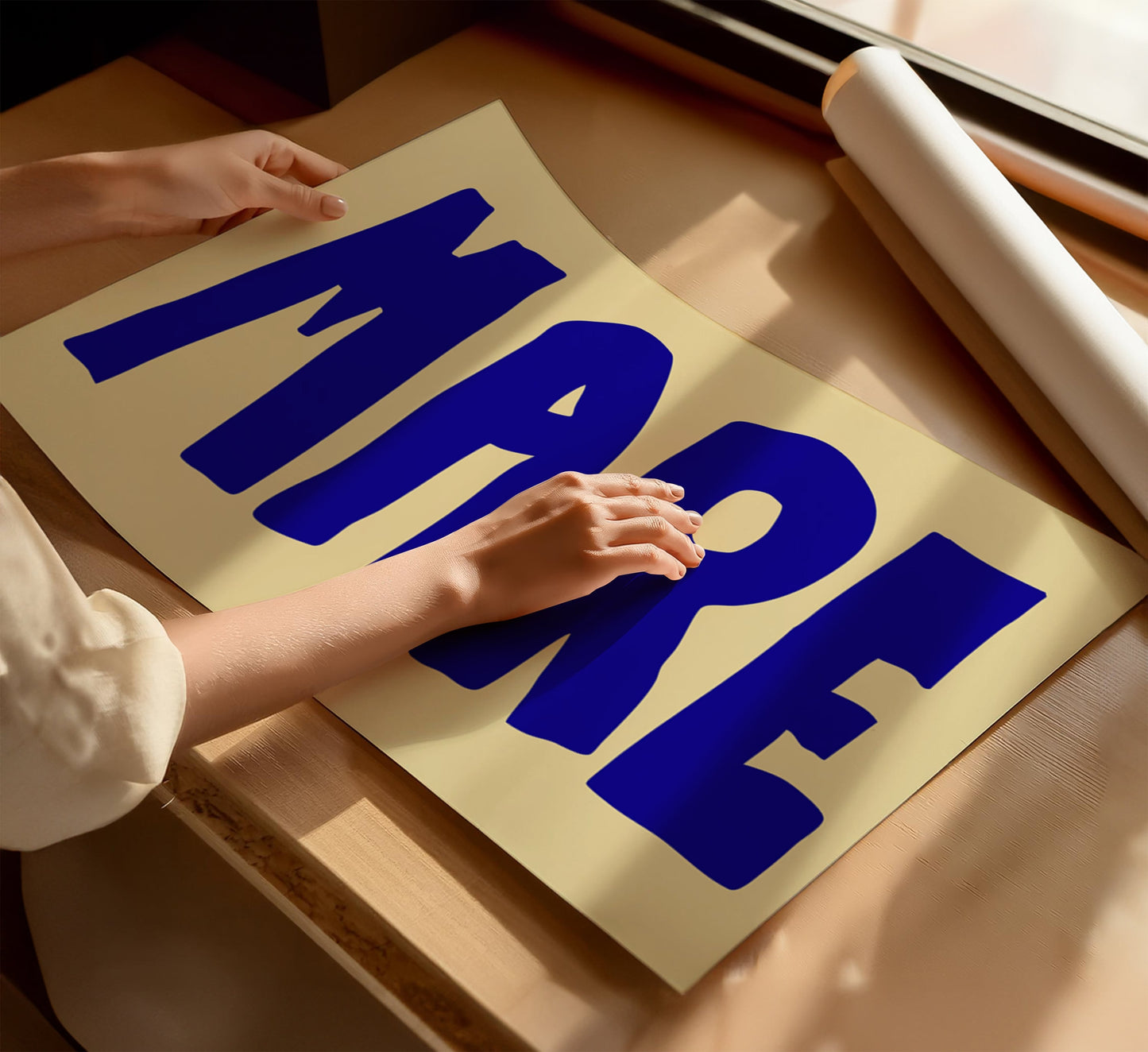 A woman touching a minimalist poster with the Italian word “MARE" for ocean, in bold blue letters, on a soft warm beige background.