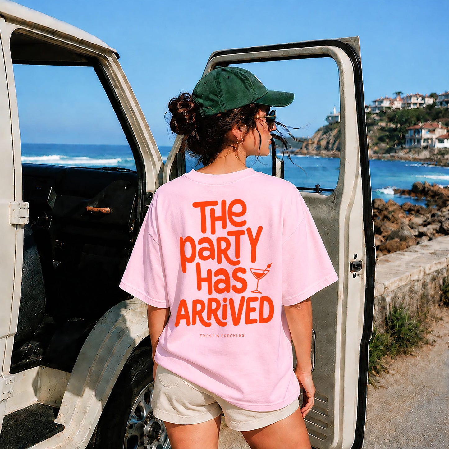 Sommerliches Lifestyle-Foto einer Frau mit grüner Cap, Shorts und dem "The Party Has Arrived" Shirt – inspiriert vom Vibe aus dem Podcast Kaulitz Hills.