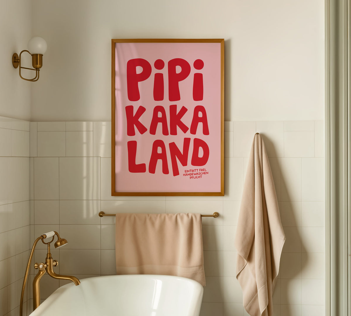 Gerahmtes Klo-Wandbild „Pipi Kaka Land“ in einem hellen Holzrahmen an der Fliesen Wand im Bad über der Badewanne.