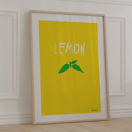 Lemon themed, framed print leaning against kitchen wall with soft, warm wind blowing kitchen curtains around