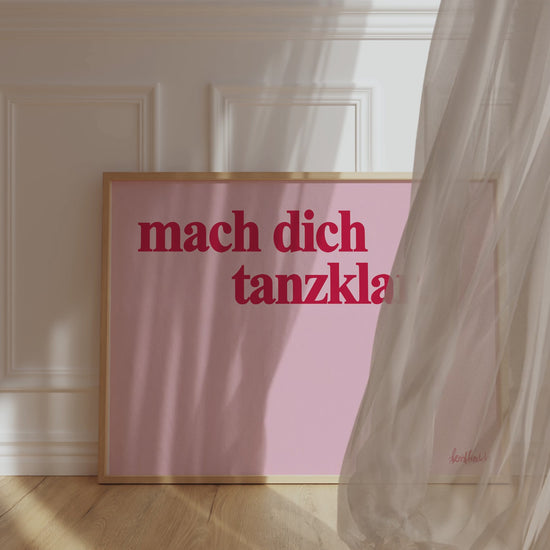 Gerahmtes Poster in horizontalem Format zeigt den Spruch "mach dich tanzklar" in roter Schrift auf pinkem Hintergrund.