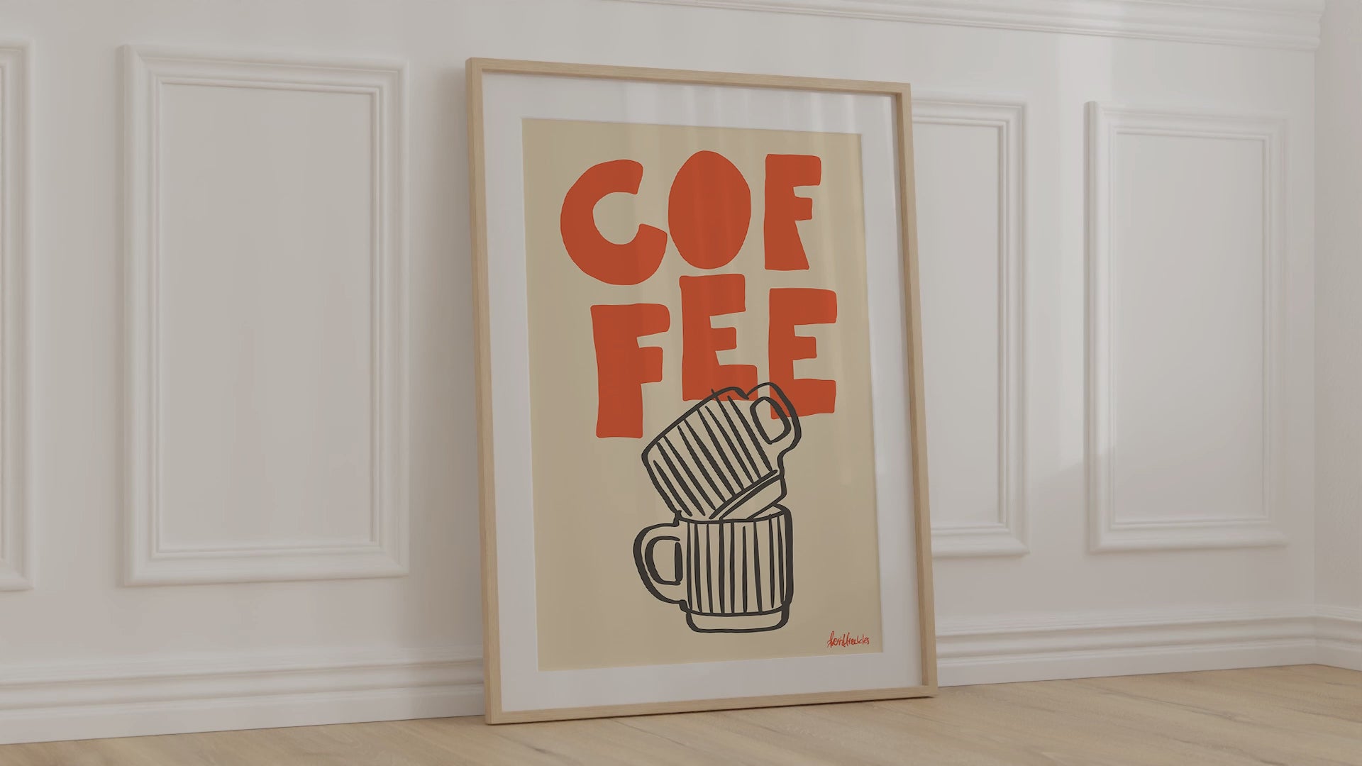 A framed picture leaning against a bedroom wall, beige background and bold orange letters reading "COFFEE"