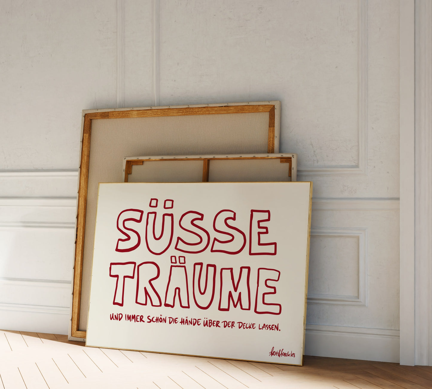 Ein gerahmtes "Süße Träume" Poster mit verspielter Typographie lehnt gegen eine Schlafzimmerwand.