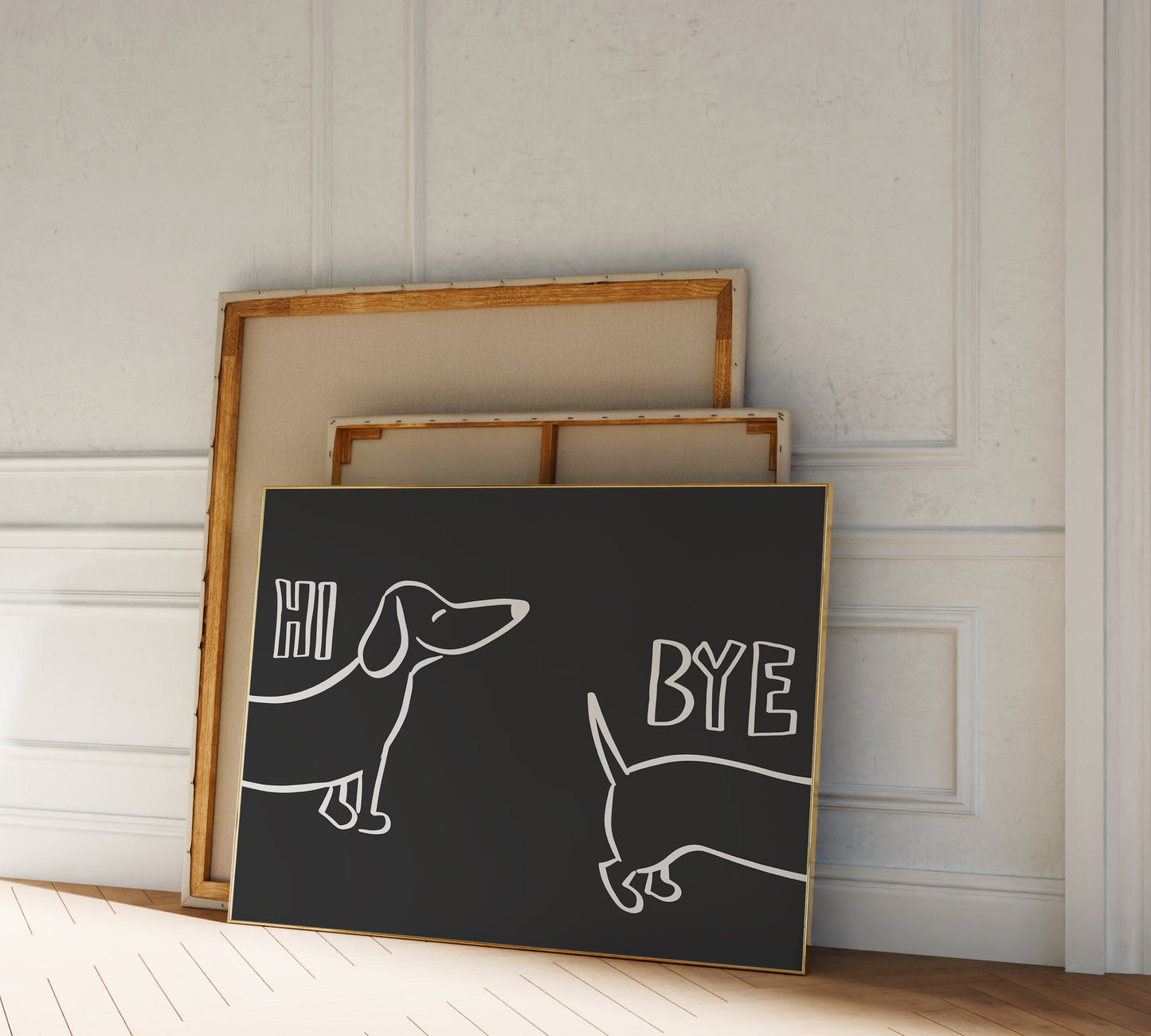 A picture frame leaning against a wall, black background and light lettering reading "hi bye" alongside a funny sausage dog drawing.