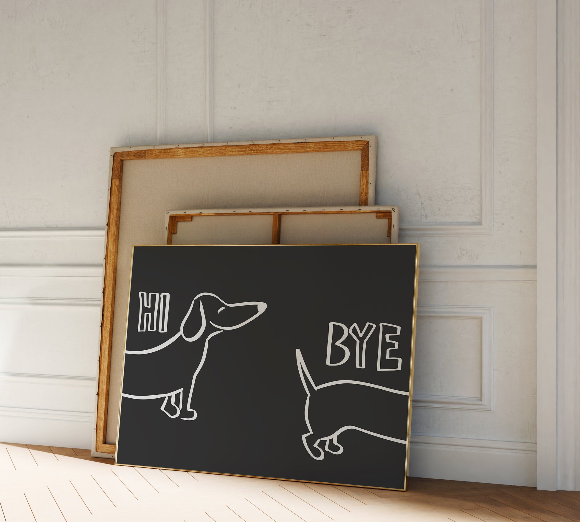 A picture frame leaning against a wall, black background and light lettering reading "hi bye" alongside a funny sausage dog drawing.