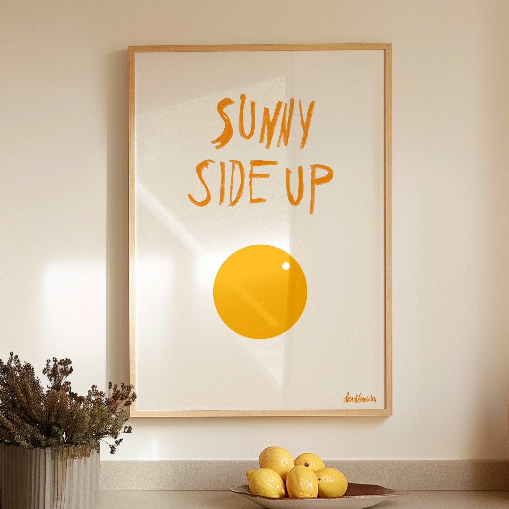 Minimalist sunny side up egg poster print with white background and orange / yellow egg illustration, framed in modern kitchen setting