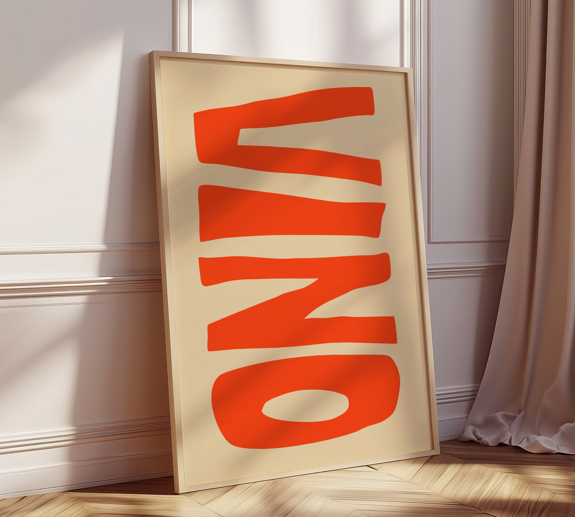 A framed picture leaning against a modern living room wall, on it written in big bold orange letters is the Italian word "VINO".